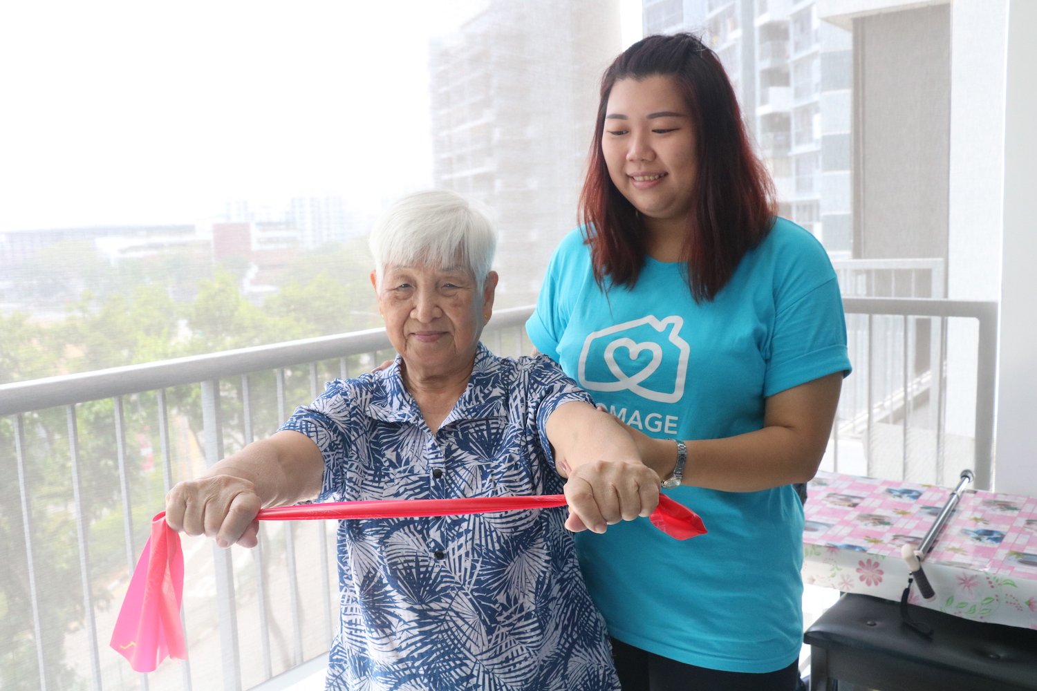 Homage Care Professional helping elderly woman to stay physically active with resistance band exercises