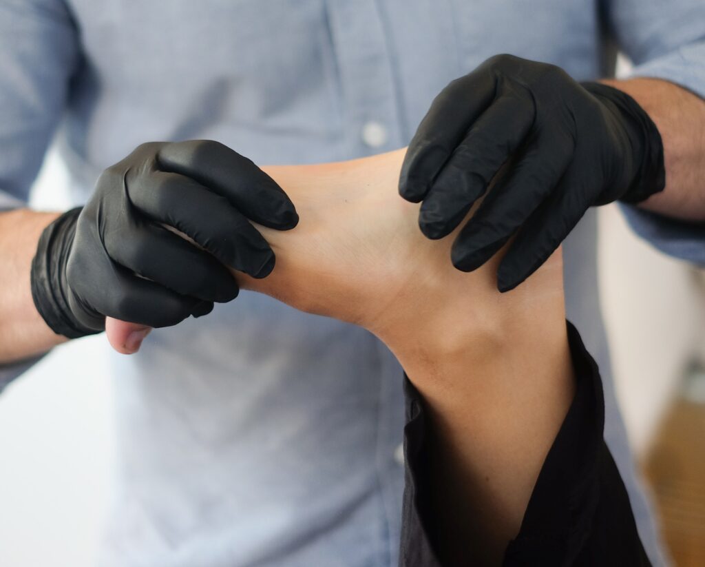 homage post surgery recovery - physiotherapist touching patient's ankle